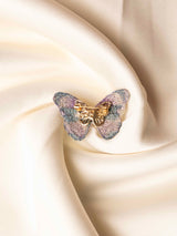 Butterfly-shaped jewelry on a soft beige fabric background
