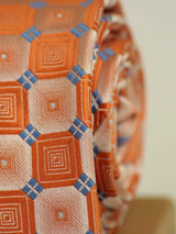 Orange geometric necktie in woven microfiber, tied view