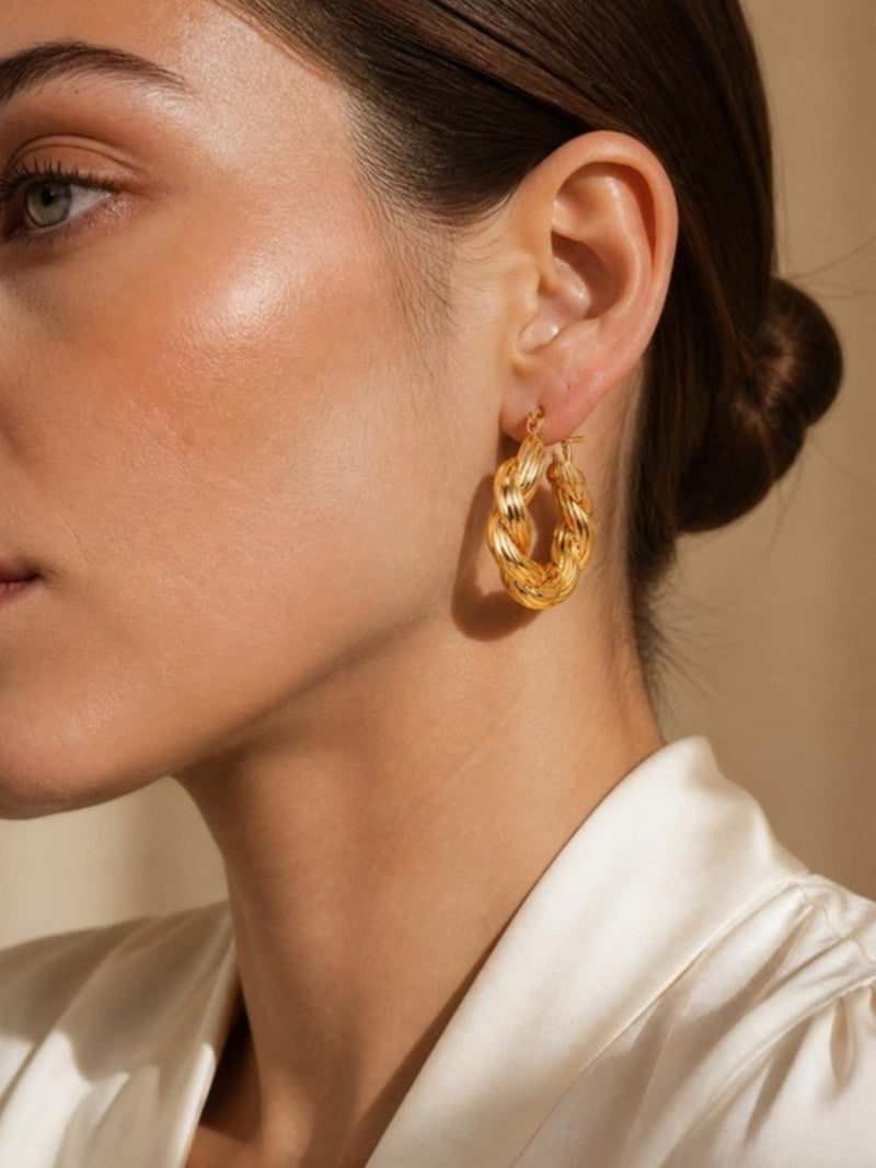 Gold twisted hoop earrings worn on model - Tossido jewellery